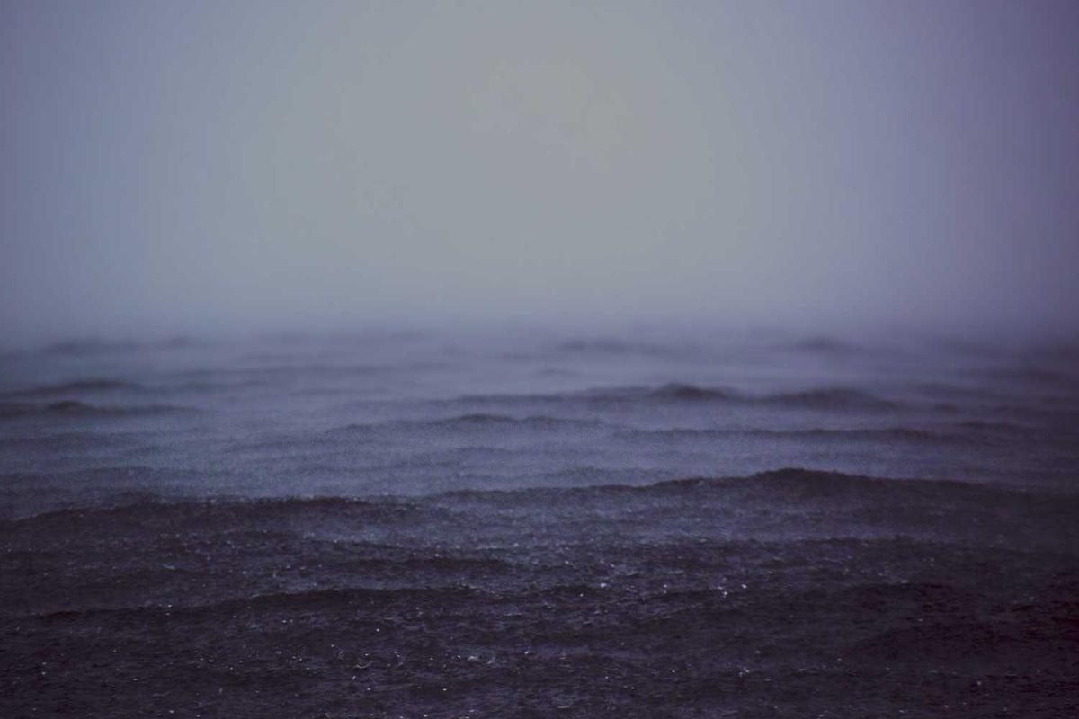 Misty ocean waves blend into a gray horizon, creating a serene, atmospheric seascape. Perfect for calming backgrounds.