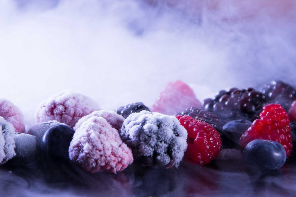 A variety of frozen berries with a smoky background creating a visually stunning effect.