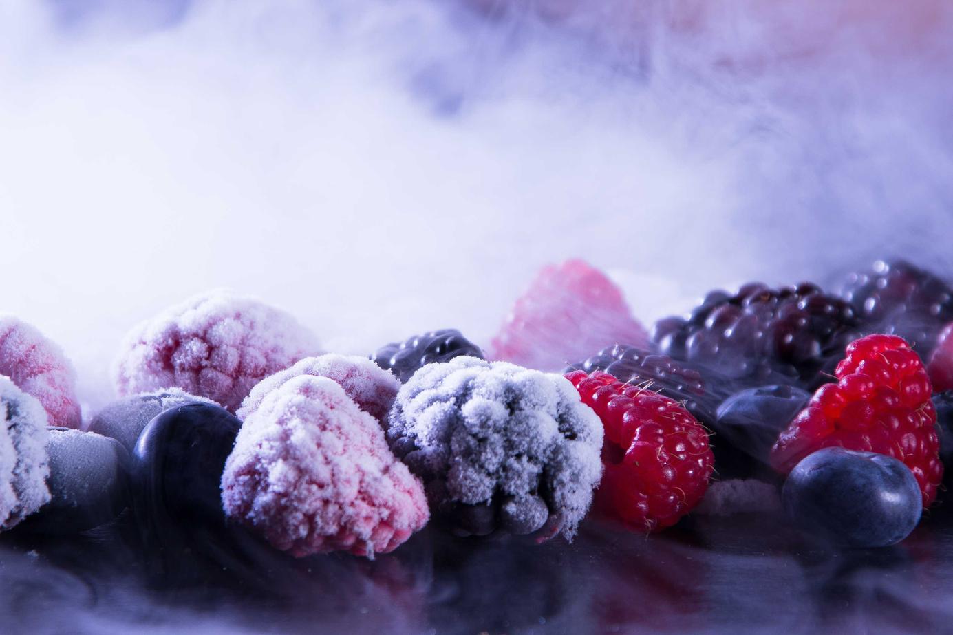 A variety of frozen berries with a smoky background creating a visually stunning effect.