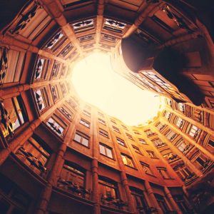 Unique upward view of a courtyard with sunlight streaming through buildings